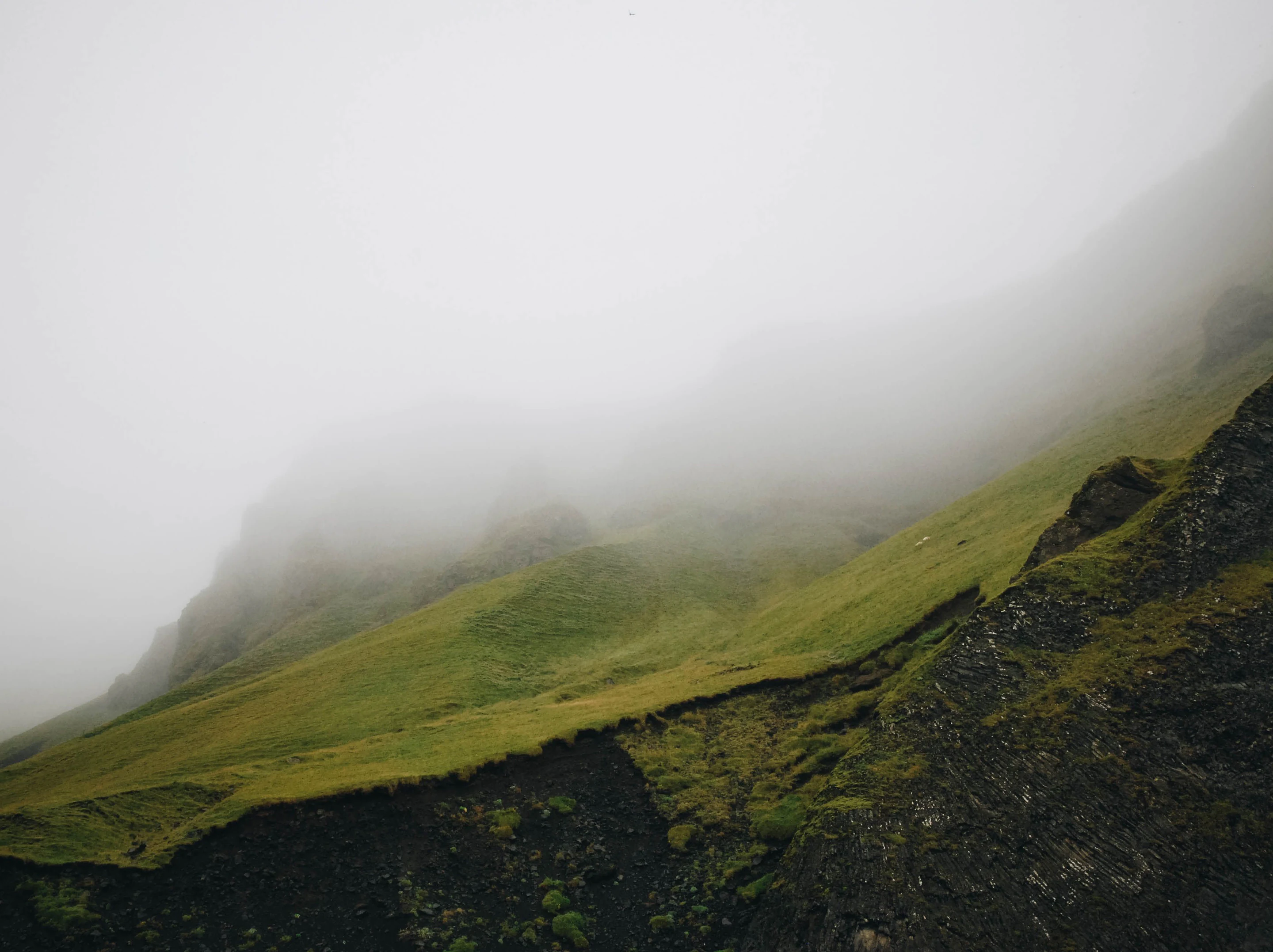 A green ridge running down into cloud